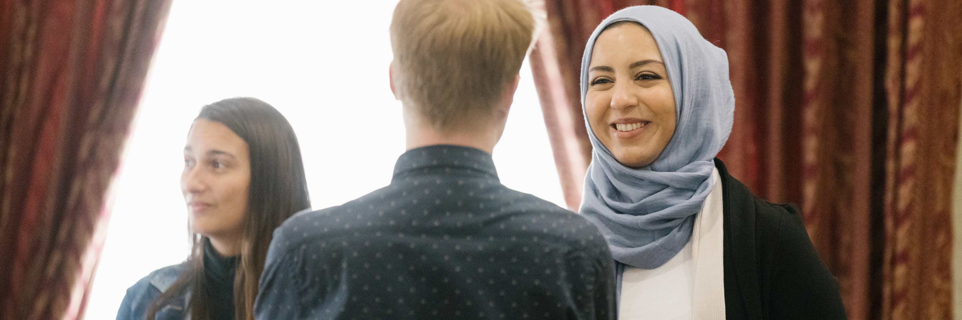 Students smiling at one another at the philosophy department's graduation celebration. 