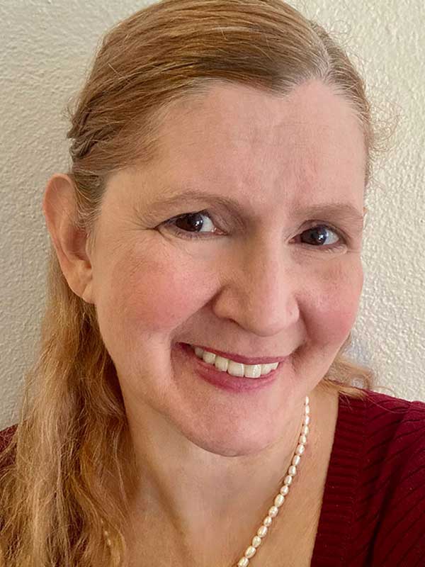 A headshot of Kate Abramson, who wears a red sweater and white necklace.
